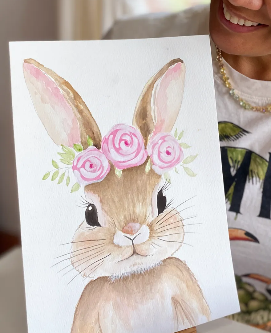 Alumna mostrando una acuarela de un conejo con flores
