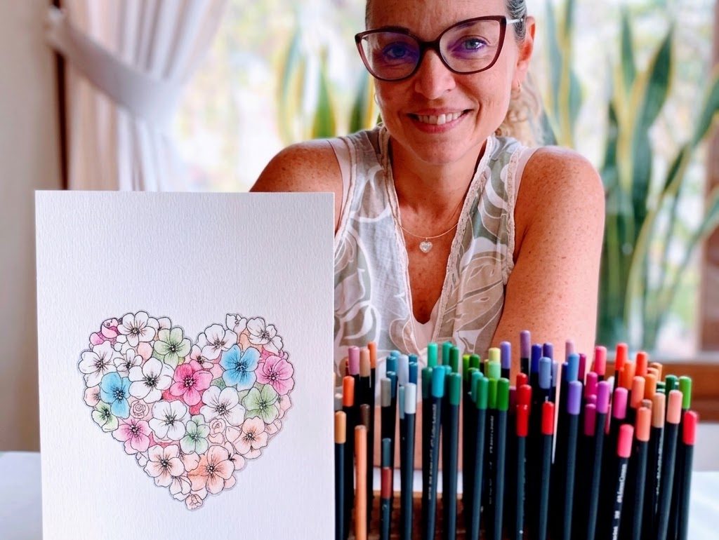 Alumna con una obra de corazón floral