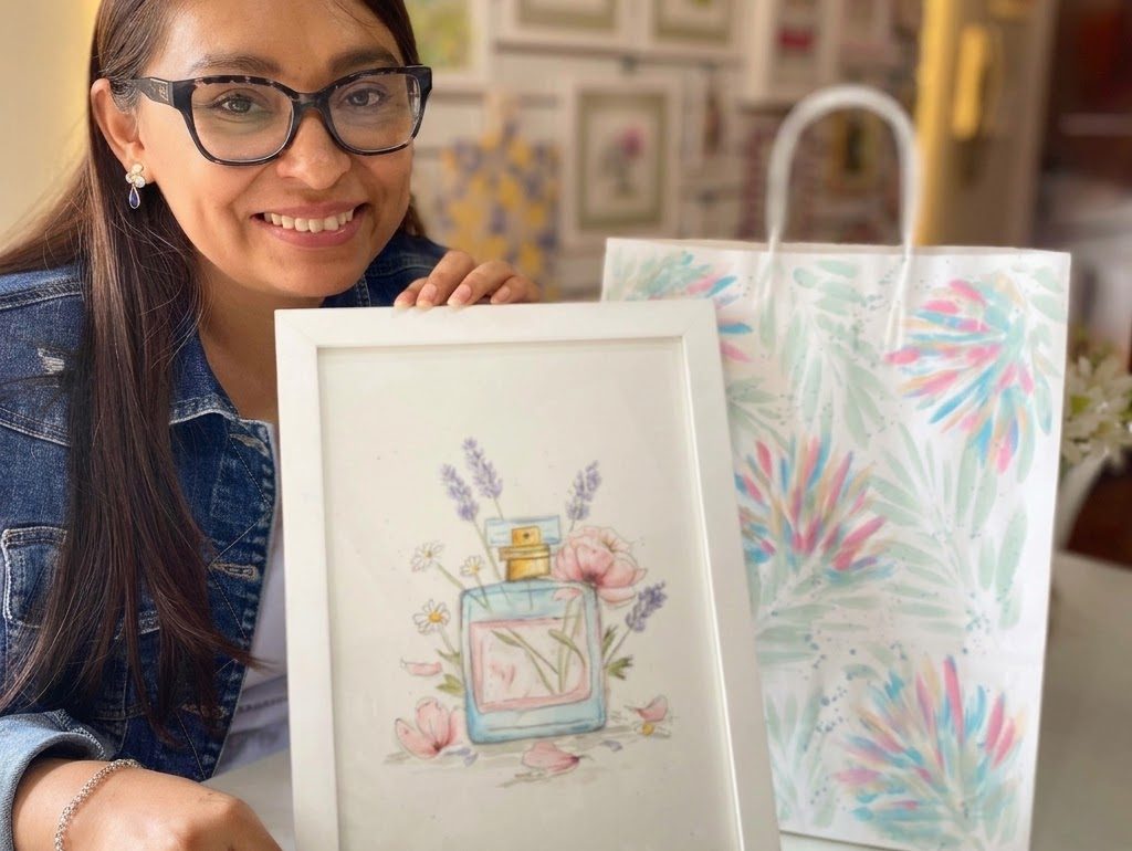 Alumna mostrando una acuarela de perfume y flores